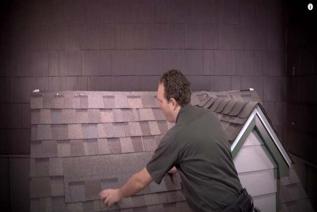 Worker installing asphalt shingles