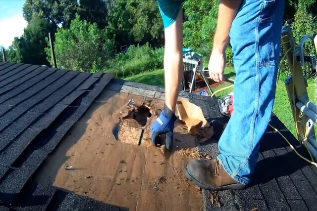 Worker repairing a hole in the leaky roof.